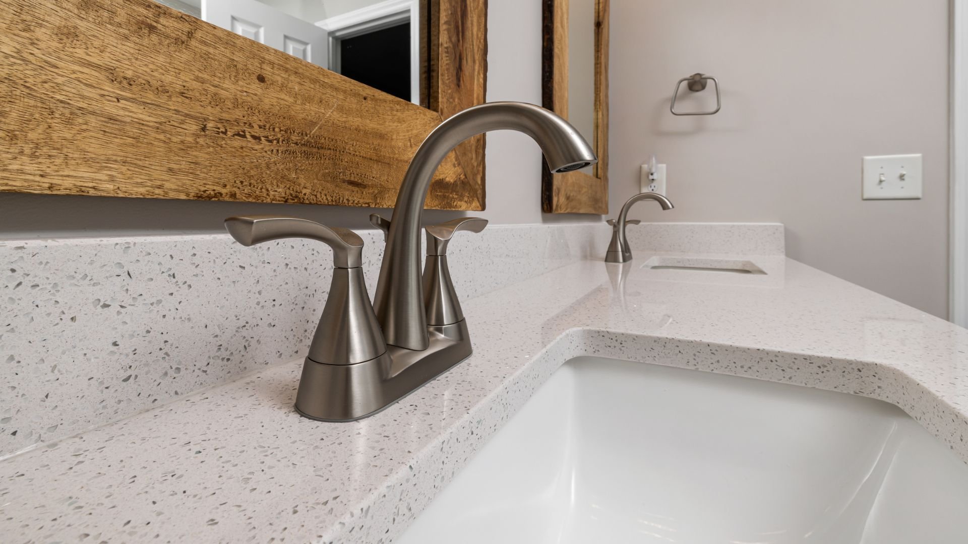 Modern bathroom sink with brushed nickel faucet and speckled countertop
